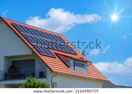 An image of a home with solar energy green plants and sunny blue sky Royalty-Free Stock Photo #2166980759
