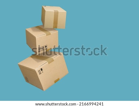 Closed and taped cardboard boxes flying isolated on turquoise blue background Royalty-Free Stock Photo #2166994241