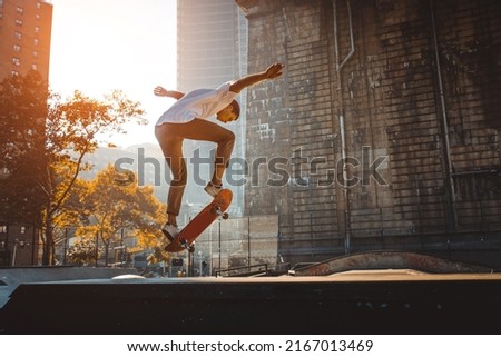 Young adult skating outdoors - Stylish skateboarder boy training in a nNew York skate park, concepts about sport and ifestyle Royalty-Free Stock Photo #2167013469