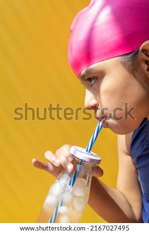 Cute little girl in a swimsuit sunbathing, while having a lemonade