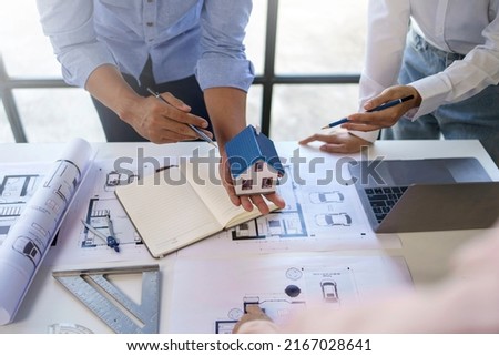 Engineer or architect meeting planning project working together and engineering tools on model building and blueprint in working site.
