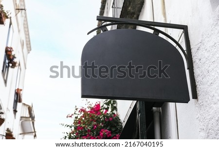 Classic wall sign mockup hung on a restaurant facade. Stock photo of a blank outdoor business signage template for branding design