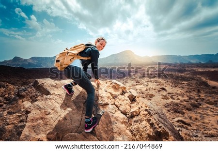 Portrait of a happy woman hiker standing on the top of mountain ridge against mountains - Sport and healthy lifestyle concept Royalty-Free Stock Photo #2167044869