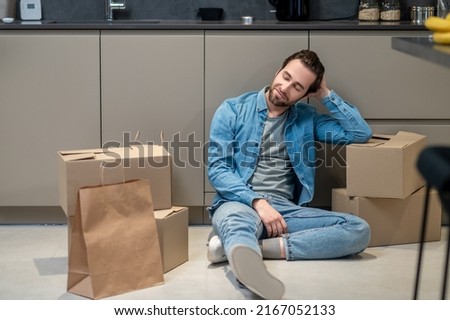 Man looking at bags and boxes sitting on floor