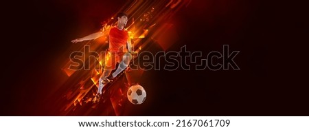 Fire. Creative artwork with soccer, football player in motion and action with ball isolated on dark background with polygonal and fluid neon elements. Concept of art, creativity, sport, energy and