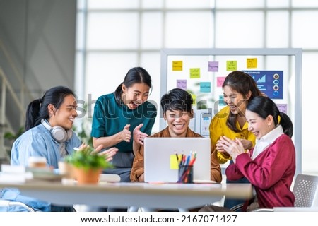 Young happy Asian business man, woman work together, celebrate clap hands in start up office. Creative team brainstorm meeting, businesspeople colleague partnership or office coworker teamwork concept Royalty-Free Stock Photo #2167071427