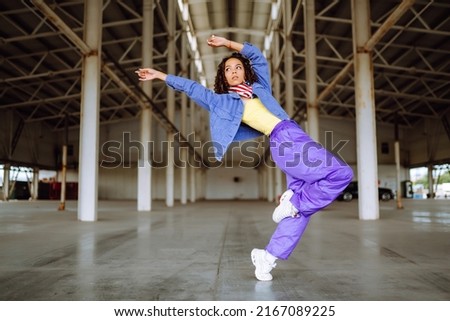 Beautiful sportive girl dancing  in stylish clothes in the underpass. Sport, dancing and urban culture concept. Royalty-Free Stock Photo #2167089225