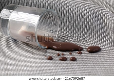 Stains of cocoa milk on the fabric that children may pour on the sofa to promote washing machine or cleansing solution.