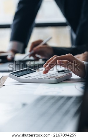 Businessman using a calculator to calculate numbers on a company's financial documents, he is analyzing historical financial data to plan how to grow the company. Financial concept. Royalty-Free Stock Photo #2167094259