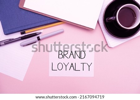 Text caption presenting Brand Loyalty. Business idea Repeat Purchase Ambassador Patronage Favorite Trusted Office Supplies Over Desk With Keyboard And Glasses And Coffee Cup For Working Royalty-Free Stock Photo #2167094719