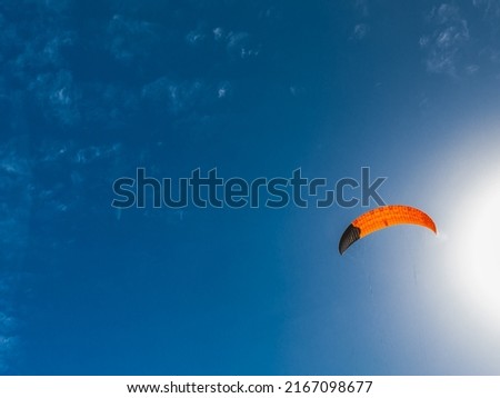 Bright red kite on blue sky background. Kitesurfing on Cyprus.