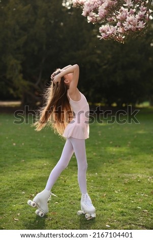 Beautiful girl with long hair in the park. Girl on roller skates. The girl smiles. Quad rollers.
