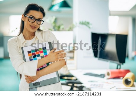 Female digital designer looking at swatches at an office