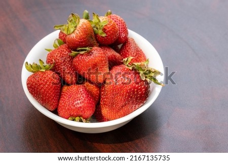 Close up of a bowl of fresh organic strawberries with natural light
