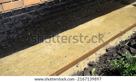 Sand is poured with water to lay paving slabs. The process of laying paving slabs. Humidification of sand for paving slabs. Sand is poured from a hose.