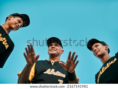 Above all, have fun. Shot of a baseball coach talking to his team while out on the pitch.