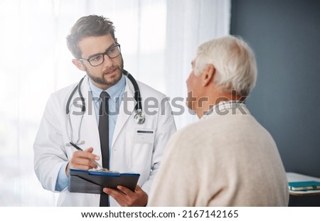 Lets set up an appointment for next week. Cropped shot of a young male doctor going through medical records with his senior male patient. Royalty-Free Stock Photo #2167142165