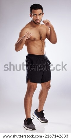 Follow through with determination. Shot of a young man practicing his punches against a studio background. Royalty-Free Stock Photo #2167142633