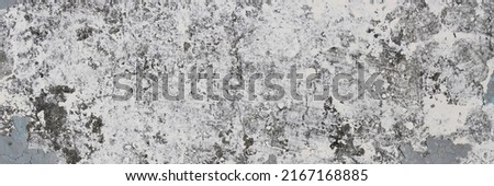 Peeling paint on the wall. Panorama of a concrete wall with old cracked flaking paint. Weathered rough painted surface with patterns of cracks and peeling. Wide panoramic texture for grunge background Royalty-Free Stock Photo #2167168885