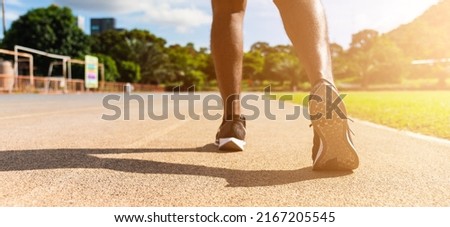 Asian young athlete sport runner black man wear feet active ready to running training at the outdoor on the treadmill line road for a step forward, healthy exercise workout, closeup back shoe Royalty-Free Stock Photo #2167205545