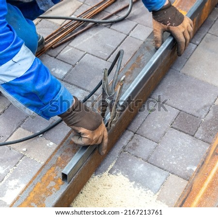 A worker works with metal at a construction site. Technology