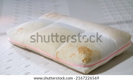 White pillow with yellow saliva stains