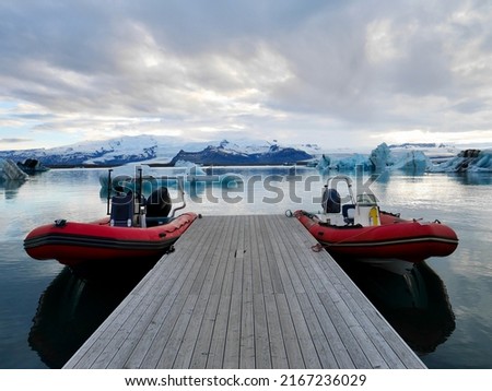 Red zodiac boats in Jökulsarlon glacier lagoon at sunset. . High quality photo