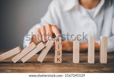 close-up hand The hand of a businessman who is stopping or preventing a falling block.Risk protection concept,Eliminating the risk.	

 Royalty-Free Stock Photo #2167245529
