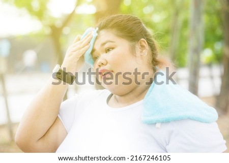 Picture of tired fat woman having headache while exercising at the park while