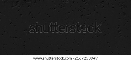 black damaged stucco wall with cracks and peeling paint flakes