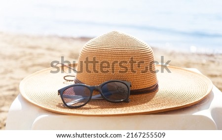 Straw hat and sunglasses on the beach. Beach holiday concept.  Royalty-Free Stock Photo #2167255509