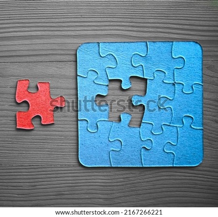 completing whole puzzle with last piece. photo for business design and infographic. jigsaw  with missing pieces in the center. Missing Jigsaw puzzle piece. wooden table surface. top view.