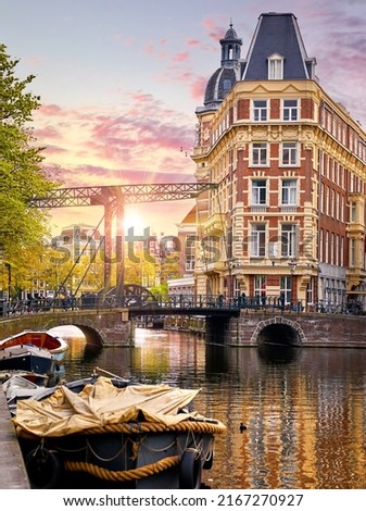 Amsterdam, Netherlands. Panoramic view of autumn Dutch city. Famous channel of Amstel river. Evening cityscape. Colorful sunset scene of famous travel destination in Europe. Romantic traveling place. Royalty-Free Stock Photo #2167270927