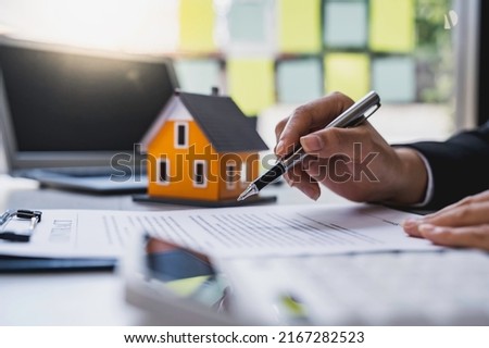 Real estate agent working sign agreement document contract for home loan insurance approving purchases for client with house model and key on table