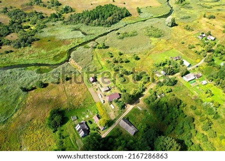 Country houses at river in countryside, aerial view. Building a Home in the Country. Village with wooden house. Suburban house in rural on sunset. Rural building and farmhouse at lake in countryside.  Royalty-Free Stock Photo #2167286863