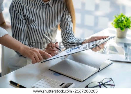 Analysis, Discussion, Asian woman economist and marketer pointing to a financial data sheet to plan, Negotiation Royalty-Free Stock Photo #2167288205