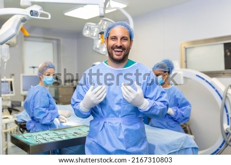 Portrait of male surgeon standing in operating room, ready to work on a patient. Male medical worker surgical uniform in operation theater.
