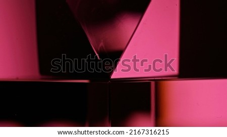 Neon cyberpunk glow. Geometric texture. Futuristic radiance. Fluorescent pink black color gradient mirror glass cube on dark abstract art background.
