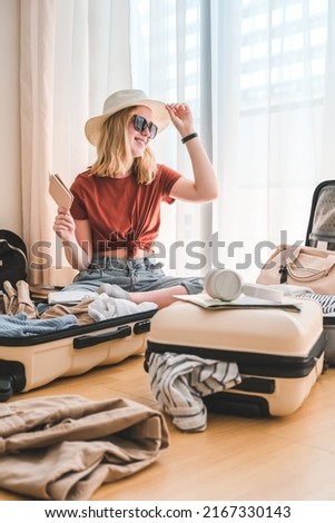 Travel. Staycation.local travel new normal.Girl packing luggage in suitcase and travel documents Travel,tourism,vacation,relocation.Mental health and travel vacation Film grain Royalty-Free Stock Photo #2167330143