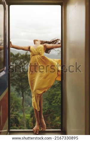 Travel and Exploration of Tourist Woman by Train to Famous Landmarks in Sri Lanka. Romantic young traveler woman enjoying extreme fun train ride from Ella to Kandy among tea plantations in the Royalty-Free Stock Photo #2167330895