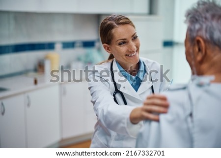 Happy general practitioner and her senior patient talking during medical exam at doctor's office. Royalty-Free Stock Photo #2167332701