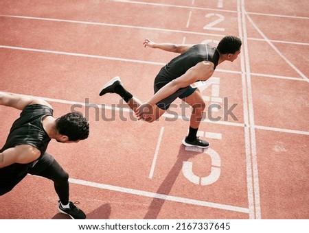 Hes stolen it. High angle shot of two handsome young male athletes crossing the finishing line during their race on a track. Royalty-Free Stock Photo #2167337645