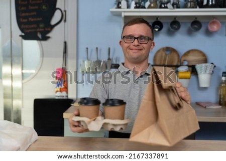 Caucasian man with down syndrome serving food to take away Royalty-Free Stock Photo #2167337891