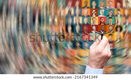 Hand with magnifying glass searching human resources among diverse business people as career and team concept Royalty-Free Stock Photo #2167341349