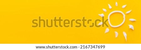 Top view of white sun sign from sunscreen cream on yellow background, banner Royalty-Free Stock Photo #2167347699