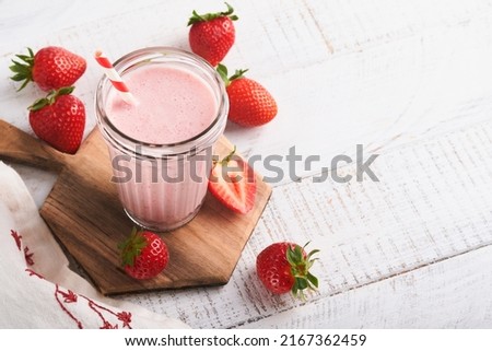 Strawberry smoothie. Vegan smoothie or milkshake from strawberry, banana and mint on white wooden table background. Clean eating, alkaline diet. Top view. Mock up. Royalty-Free Stock Photo #2167362459