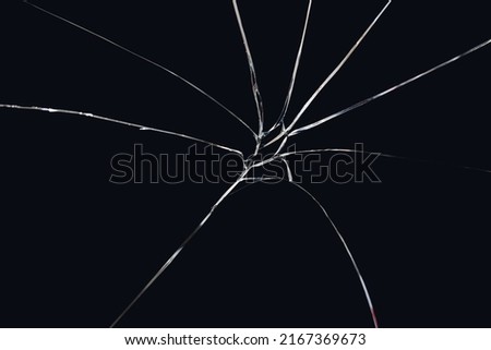 Texture broken glass with cracks on black background. Abstract cracked screen
