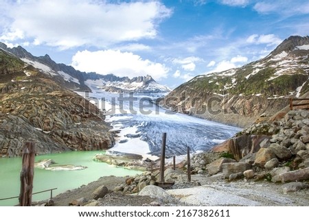 Scenic view on Rhone Glacier in swiss Alps with the lake. High mountains landscape, arid terrain of Rhonegletscher, mountain trail in Switzerland.  Royalty-Free Stock Photo #2167382611