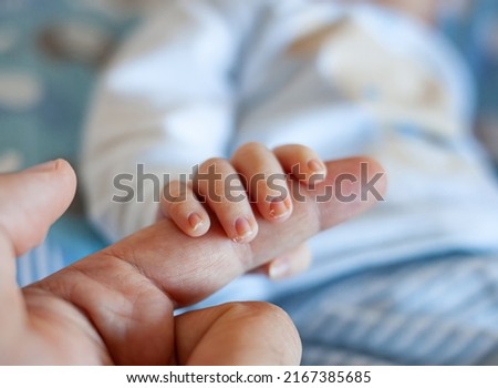 Detail of the fingers of a newborn, especially the nails. Newborn babies have long, sharp nails full of nerve endings. Royalty-Free Stock Photo #2167385685