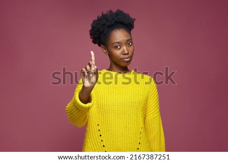 African american girl warning raised forefinger up, does admonishing gesture, giving advice to avoid danger, disapprove Royalty-Free Stock Photo #2167387251
